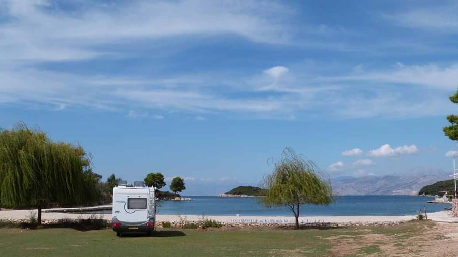Camper aan stil strand in Albanië.