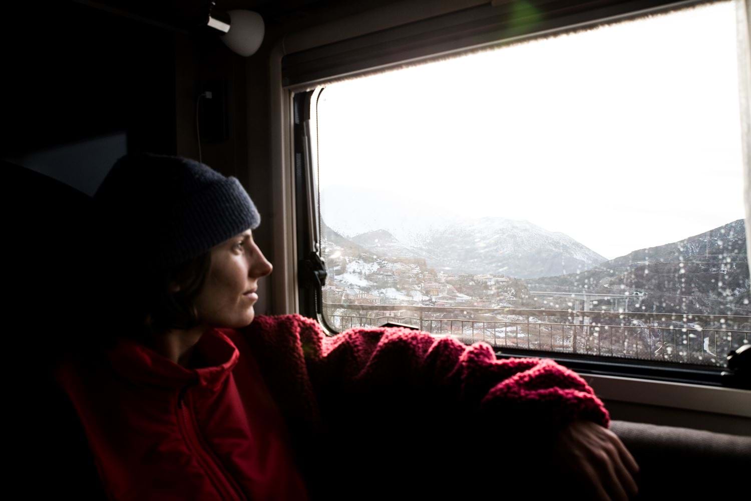 vrouw in camper met uitzicht op winters landschap