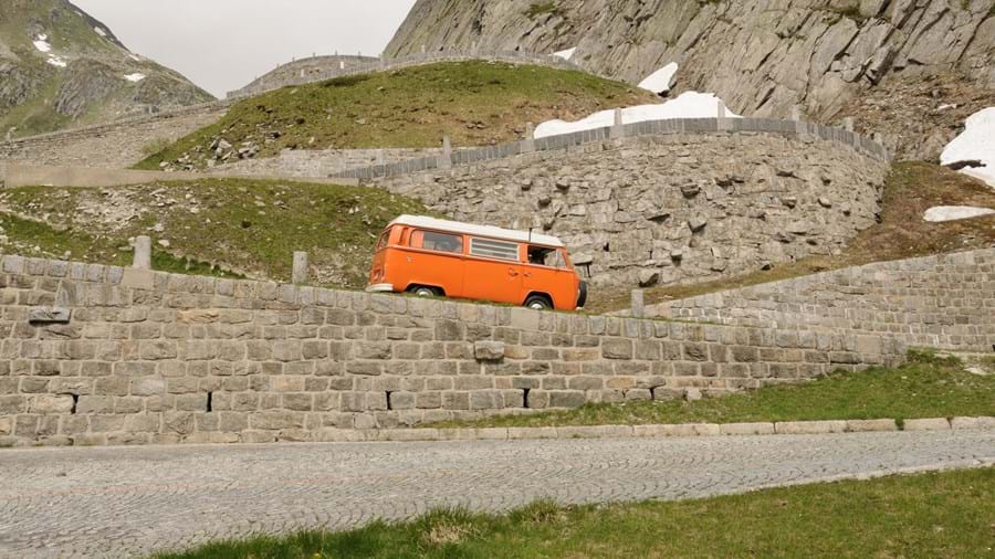 Volkswagen camperbus op steile bergpas met talloze haarspeldbochten