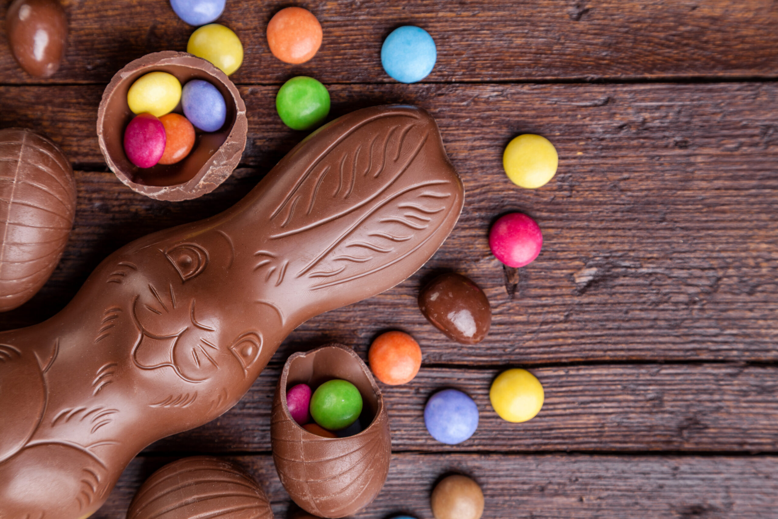 Chocolate easter eggs and sweets on wooden background