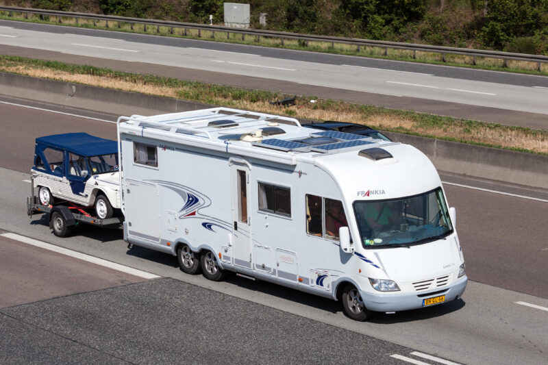 Frankia Luxury Class mobile home with a trailer moving south on the highway