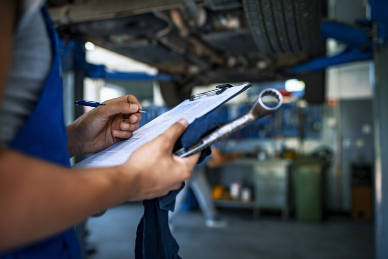 Automotive specialist adjusting an engine